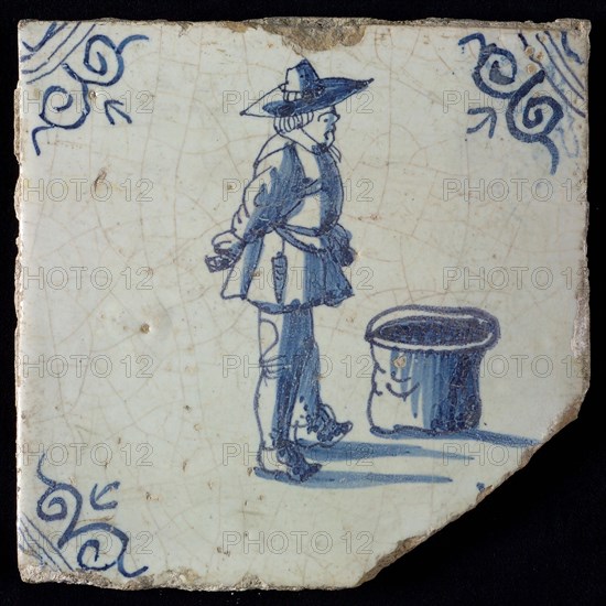 Occupation tile, blue with warrior standing by barrel, corner motif oxen head, wall tile tile sculpture ceramic earthenware