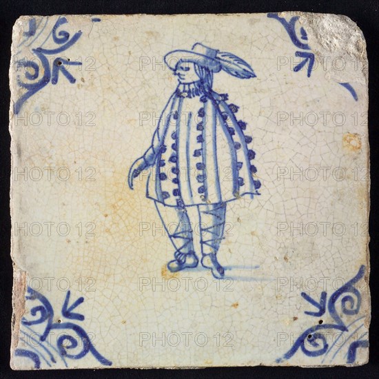 Figure tile, blue with standing man with nopjescape and hat with plume, corner pattern ox head, wall tile tile sculpture ceramic