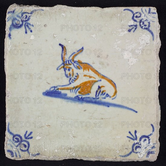 Animal tile, lying bovine to the left, in blue and brown on white, corner motif oxen head, wall tile tile sculpture ceramic