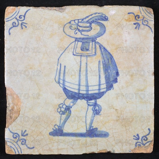 Figure tile, blue with nobleman seen on the back, wide cape and big hat with plume, corner pattern ox head, wall tile
