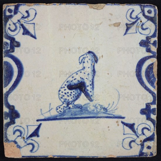Animal tile, sitting panther with averted head to the right on ground between balusters, in blue on white corner pattern french