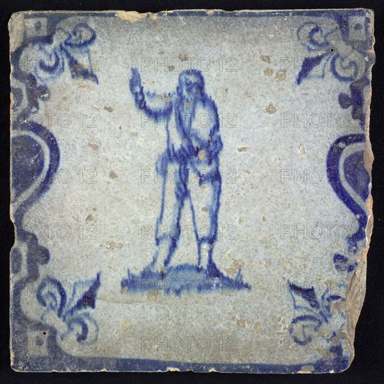 Figure tile, blue with pointing man, between balusters with French lily, wall tile tile sculpture ceramic earthenware glaze