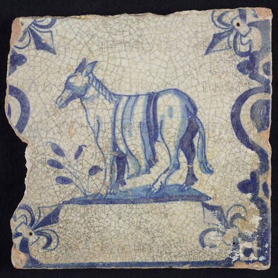 Animal tile, standing donkey or horse to the left on plot between balusters, in blue on white, corner pattern French lily, wall