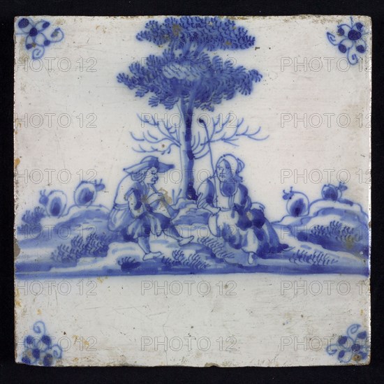 Figure tile, blue with an amiable shepherd scene with shepherd and shepherdess, sitting at tree, corner motif spider, wall tile