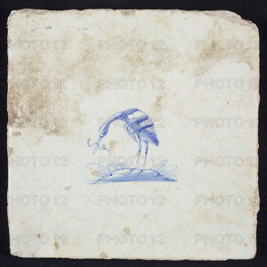 Animal tile, bird on plot with long fish in its beak to the left, blue on white, no corner pattern, wall tile tile sculpture