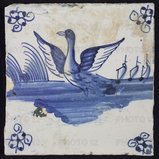 Animal tile, flying swan to the left in continuous water, in the background vegetation and ships, in blue on white, corner motif