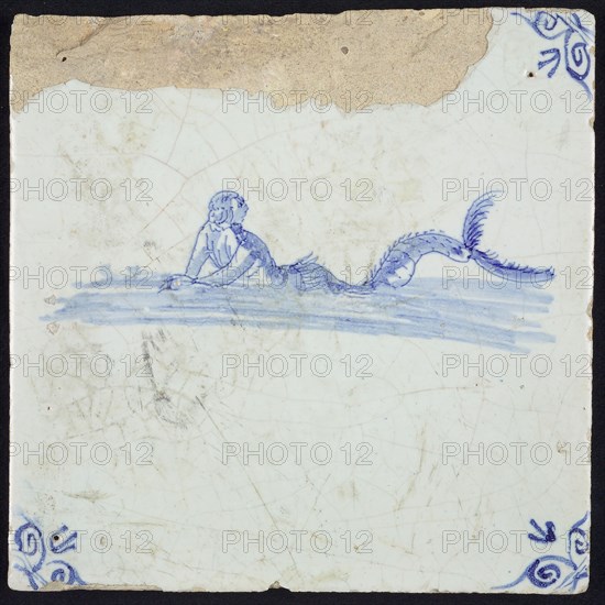 Sea creature tile, man with fish tail in water to the left, in blue on white, corner motif, ox-head, wall tile tile sculpture