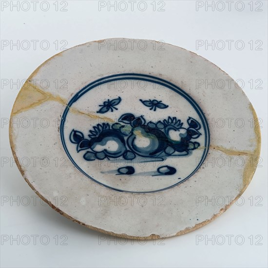 Faience plate on stand, blue decor on white background, fruit and insects, plate crockery holder soil find ceramic pottery glaze