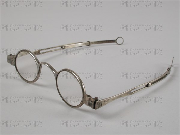 Glasses with oval lenses on strength, silver frame and adjustable straight feathers, spectacle eye lens equipment glass metal