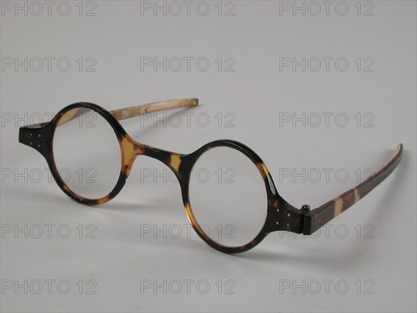 Glasses with round lenses on strength, frame of yellow-brown flamed tortoise with narrow flat straight feathers, spectacles