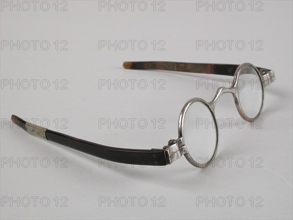 Glasses with round lenses on strength, silver-colored metal frame and short flat feathers of turtle, children's glasses
