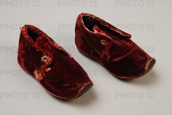 Dark red velvet baby shoes with leather sole that curls up at the pointed nose, lacing, shoe footwear baby clothing children's