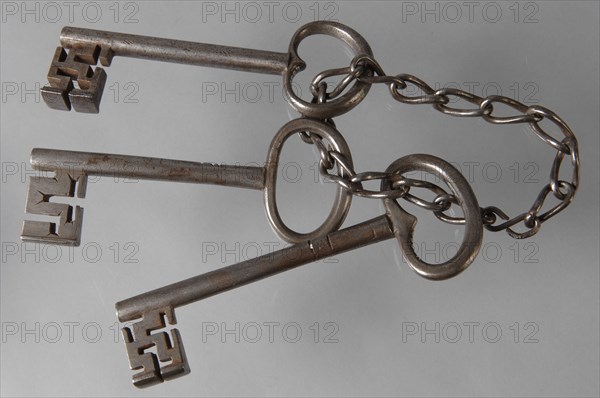 Bunch of keys: three iron keys with solid key stems and cruciform beards in beard, connected by means of an iron chain, key