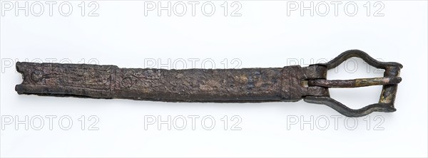 Buckle with leather fragments, long decorated strip and hinged stirrup buckle, buckle fastener part soil find bronze leather