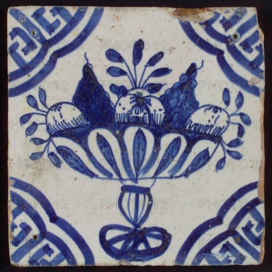 White tile with blue fruit bowl on stand, apples and grapes; corner pattern meander angle, wall tile tile sculpture ceramic