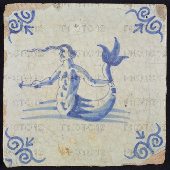 Scene tile, naked man with fish tail, holding his tail with one hand and arrow, in blue on white, corner motif oxen head, wall