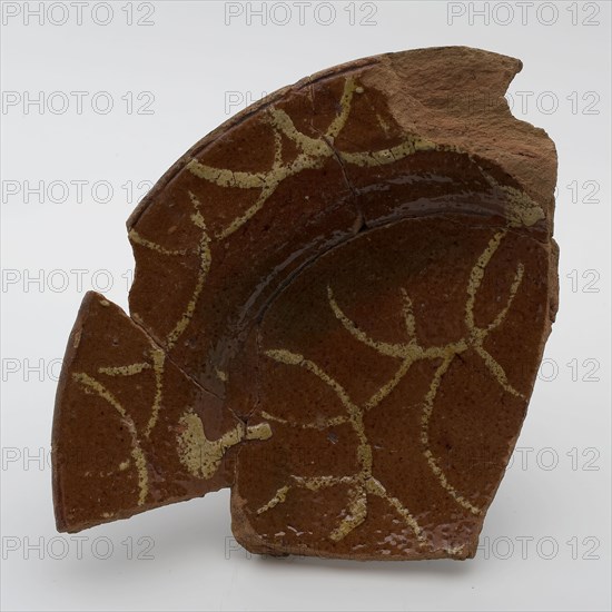 Fragment of pottery plate on stand fins, decorated with yellow arches in sludge technology, plate dish crockery holder fragment