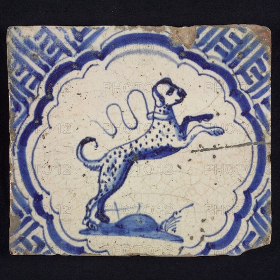 Animal tile with dog in scalloped frame, blue decor on white background, corner filling with meanders, wall tile tile sculpture