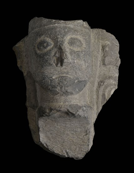 Fragment font with head on starter column, fragment font ornament limestone stone, sculpted Probably fragment of baptismal font