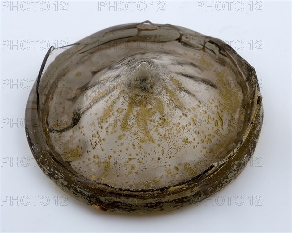 Green fragment of beaker, with burr in which green button, beaker glass bottomfound glass, archeology Rotterdam City center