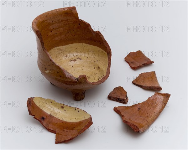 Fragments earthenware cooking jug, completely lacquered in yellow and brown, on three legs, cooking jug