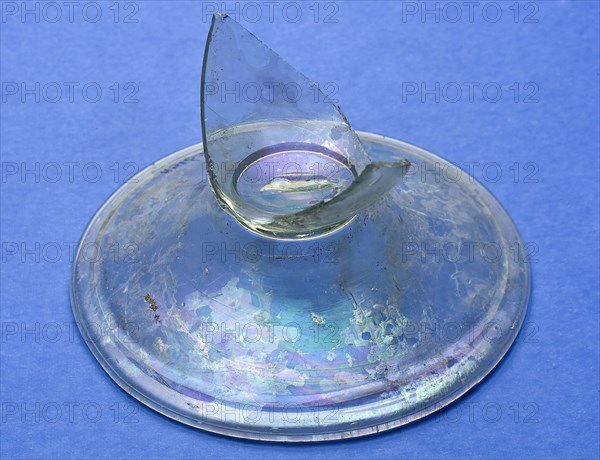 Fragment of foot and base of the body of the jug, drinking glass? drinking utensils? tableware holder soil find glass, hand