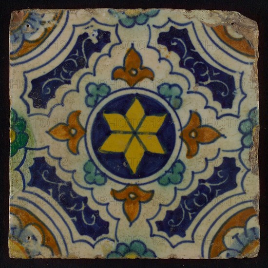 Tile, blue, green, brown and yellow on white, central yellow star in circle, sgraffito surfaces, corner motif quarter rosette