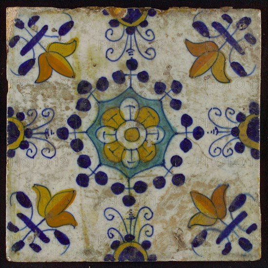 Tile, blue draft, yellow, green and orange on white, central flower within star shape, three-spot around, half rosette, corner