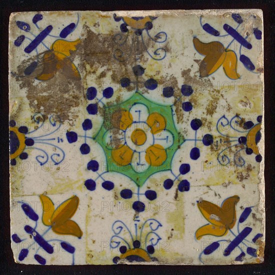 Tile, blue draft, yellow, green and orange on white, central flower within star shape, three-spot around, half rosette, corner