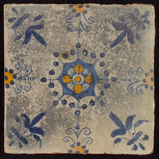 Tile, blue draft and orange on white, central flower within star shape, three-spot around, half rosette, corner pattern lily