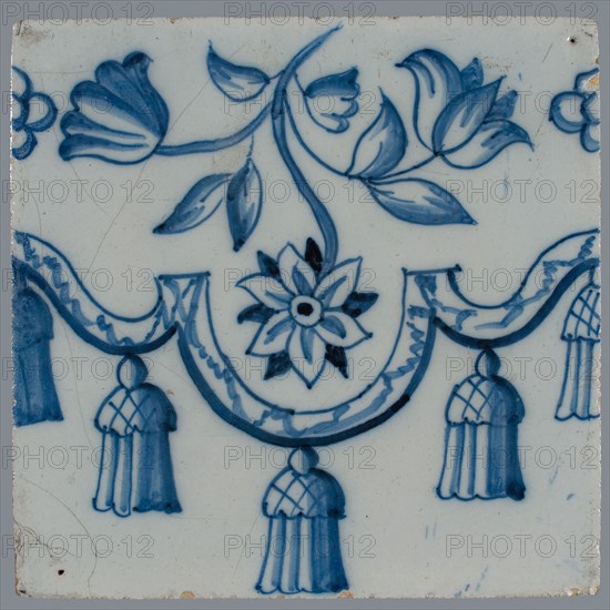 Border tile, blue on white, garland with tassels, above which flower tendril with two tulips and other flower, vertically