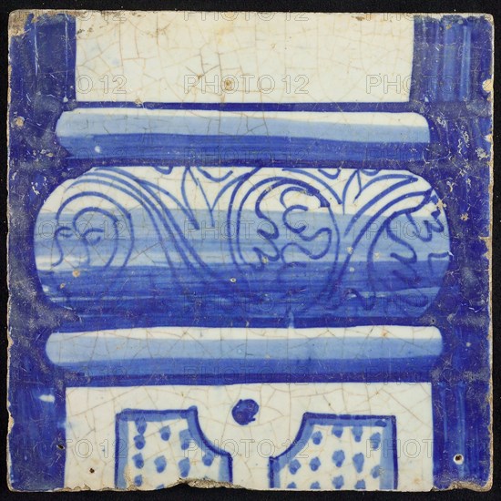 Tile of chimney pilaster, blue on white, bottom of column with basement with curly floral decoration, division with dots