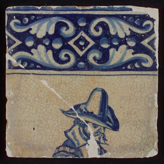 Tile of tableau with blue decorated border and man's head with hat, tile picture footage fragment ceramic pottery glaze, baked