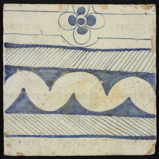 Tile of chimney pilaster, blue on white, underside, horizontal blue shaded border with white garland edge and above four