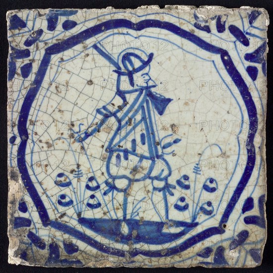 White tile with blue warrior in brace-shaped frame, corner motif wing leaf, wall tile tile sculpture ceramic earthenware glaze