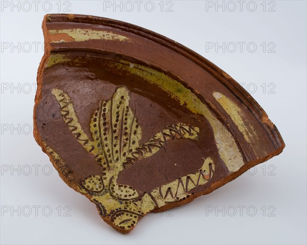 Fragment of earthenware dish on stand lobes, yellow silt decoration and sgraffitet, dish plate crockery holder soil find