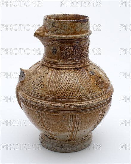 Brown stoneware jug with frieze around neck, around the belly carved ornament and stamped floral pattern, jug crockery holder