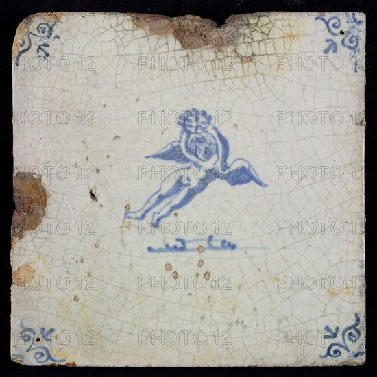 White tile with blue flying putto with laurel wreath, ox-head in the corners, wall tile tile sculpture ceramic earthenware glaze