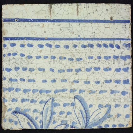 Tile of chimney pilaster, blue on white, tops of two branches with leaves, running downwards on the tile, horizontal blue lines