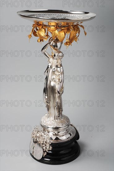 Fa. Van Kempen, Silver centerpiece, female figure on ebony base, carrying silver bowl: Minerva with the nine muses, table holder