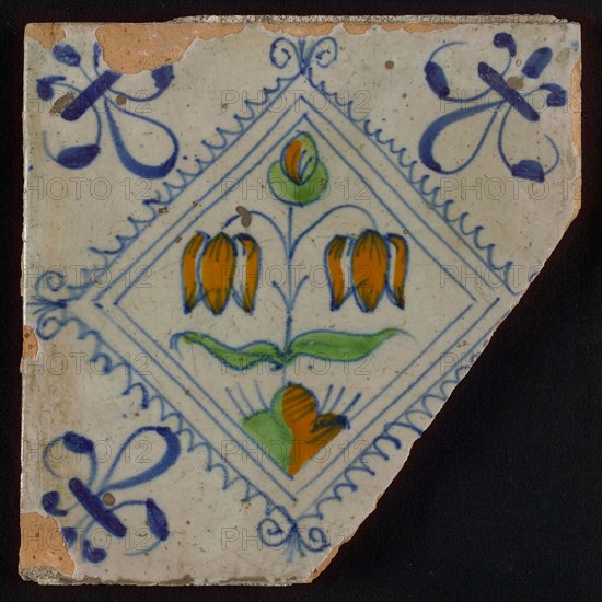 Tile, double flower on ground in orange, green and blue on white, inside serrated square with plume, corner pattern french lily