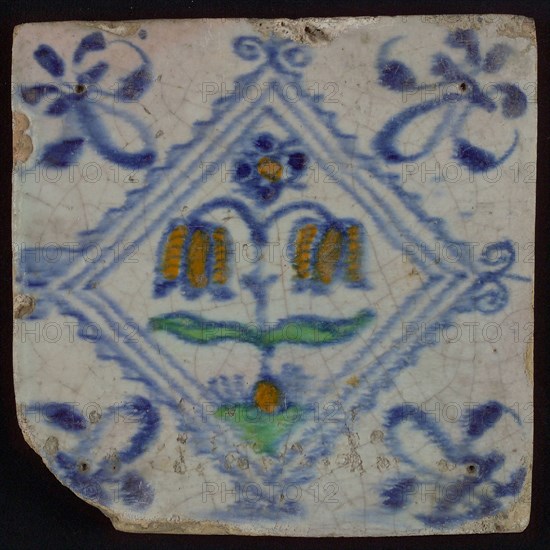 Tile, double flower on ground in orange, green and blue on white, inside serrated square with plume, corner pattern french lily