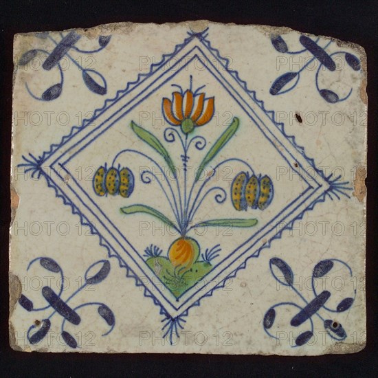 Tile, double flower on ground in orange, green and blue on white, inside serrated square with plume, corner pattern french lily