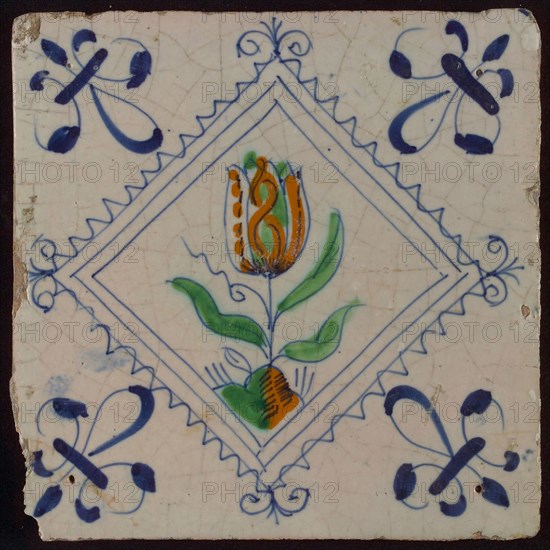 Tile, tulip on ground in orange, green and blue on white, inside serrated square with plume, corner pattern french lily, wall