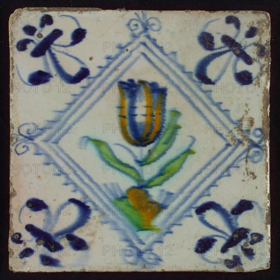 Tile, tulip on ground in orange, green and blue on white, inside serrated square with plume, corner pattern french lily, wall