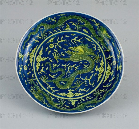 Dish with Dragons amid Clouds, Chasing Flaming Pearls, Qing dynasty (1644–1911), Qianlong reign mark and period (1736–1795), China, Porcelain painted in underglaze blue and overglaze yellow enamel, H. 4.3 cm (1 11/16 in.), diam. 25.3 cm (10 in.)