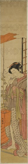 Courtesan Admiring Morning Glories while Cleaning Her Teeth, c. 1775, Isoda Koryusai, Japanese, 1735-1790, Japan, Color woodblock print, hashira-e, 28 1/4 x 4 3/4 in.