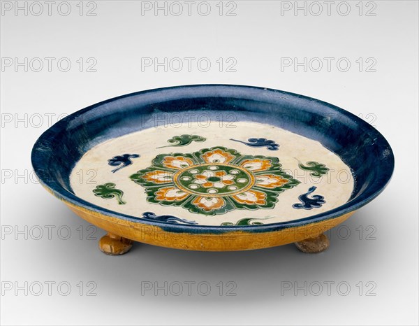 Footed Dish with Lotus Medallion and Cloud Scrolls, Tang dynasty (618–907 A.D.), first half of 8th century, China, Earthenware with impressed decoration and three-color (sancai) lead glazes, H. 6.3 cm (2.5 in.), diam. 29.5 cm (11.6 in.)