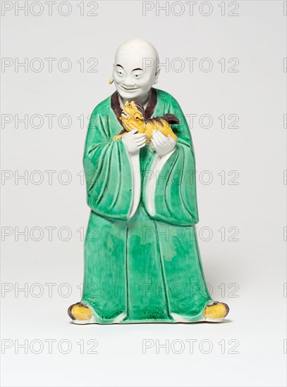 Seated Luohan Holding a Lion, Qing dynasty (1644–1911), c. 19th century, China, Porcelain painted in green, yellow, and aubergine glazes, 19.1 × 10.8 × 6.9 cm (7 1/2 × 4 1/4 × 2 3/4 in.)