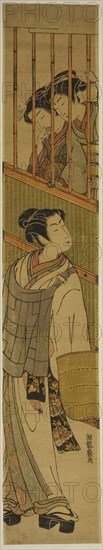 Two Young Women Looking out at Young Man Dressed as Komuso, c. 1774, Isoda Koryusai, Japanese, 1735-1790, Japan, Color woodblock print, hashira-e, 26 x 4 5/8 in.